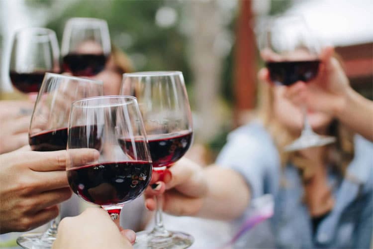 A group of people celebrating with wine glasses raised in a toast.