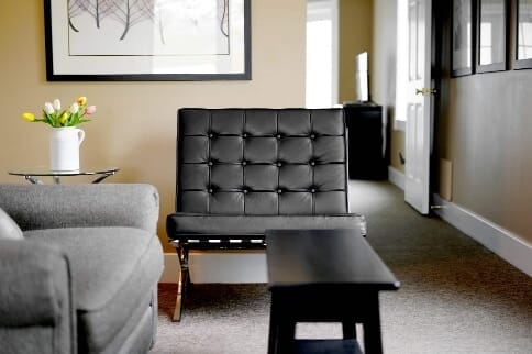 Interior with a gray chair and a black table.